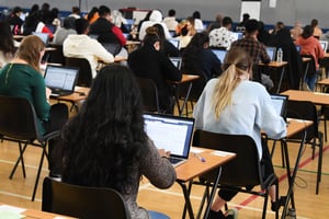 Students taking a digital exam in a gymnasium exam hall
