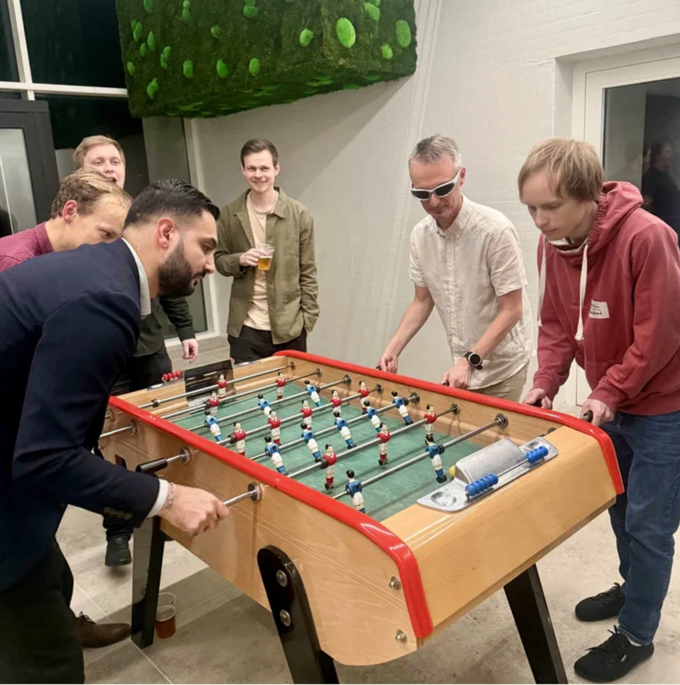 Employees of UNIwise playing foosball at a Christmas party