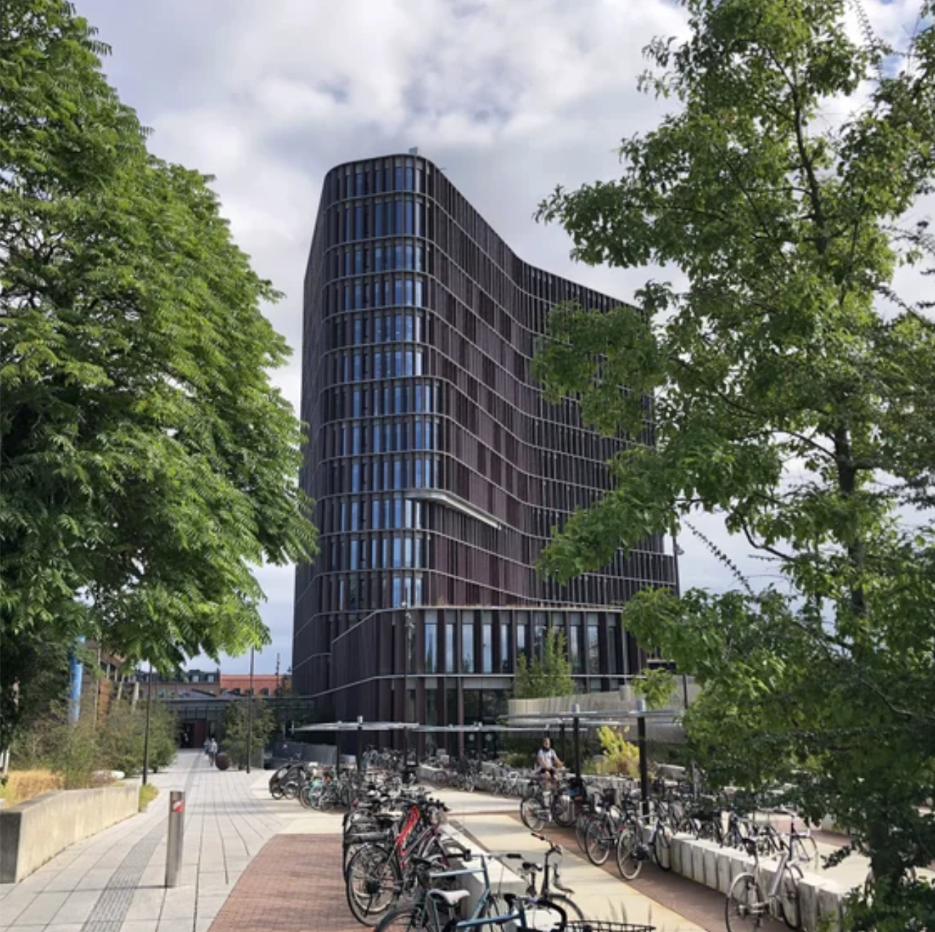 The University of Copenhagen building, featuring a large number of bicycles lined up at its entrance.