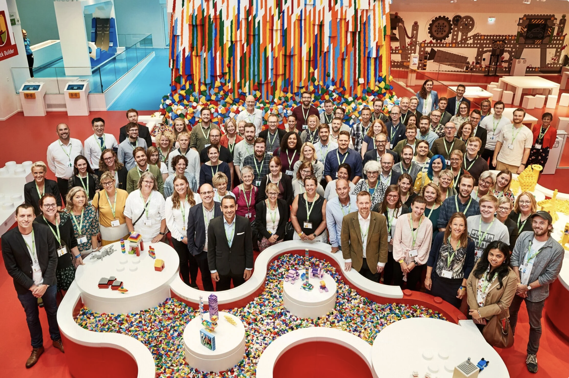 Group photo in a colourful setting of people working in EdTech