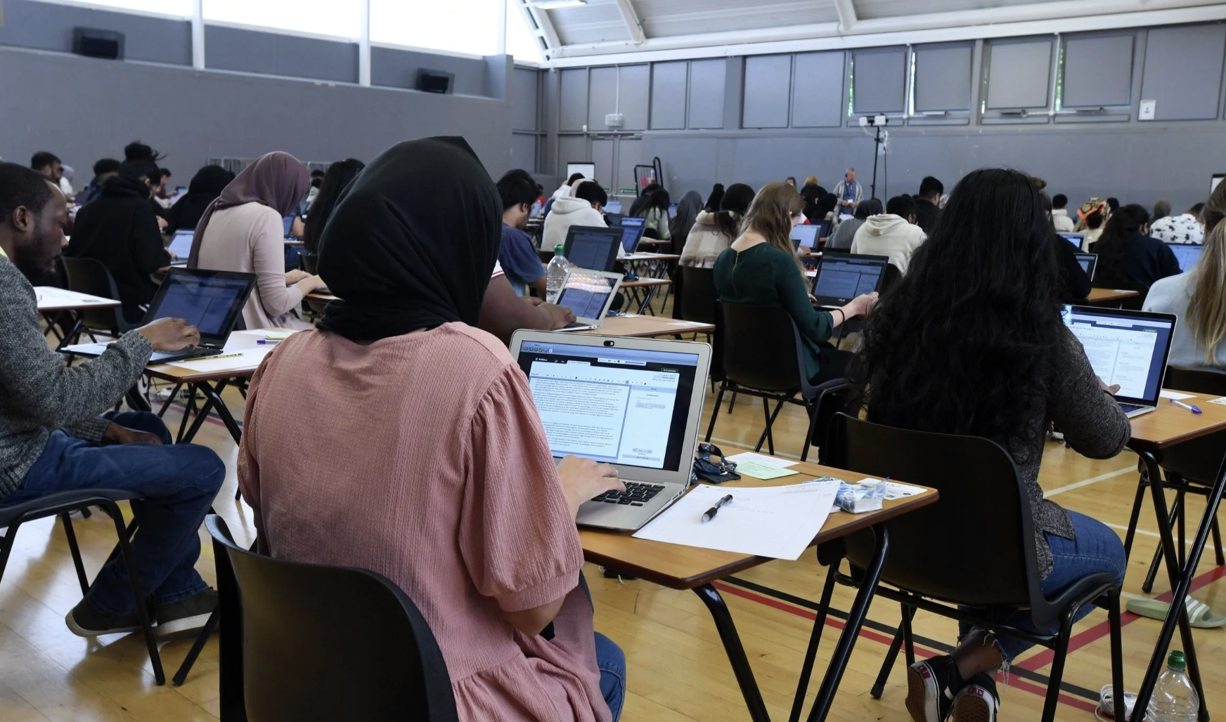 Students taking an assessment on their laptops in an exam hall
