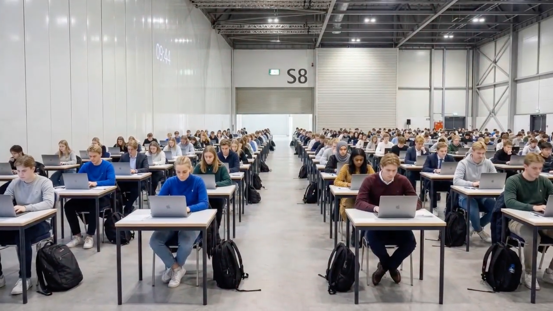 Students taking exam on their laptops in a large exam hall