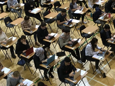 Students taking a digital assessment in an exam hall from a top-down perspective